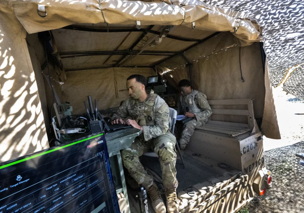 Soldiers work on the Artillery Execution Suite, a new computer system, inside a truck at Fort Carson. 